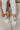Aerial view of the Newport Sneakers, which have white uppers, white chunky soles, sage green laces, and a sage green heel tab. Shoe are shown on model's feet.