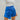 Close front view of model wearing the Bright Idea Skort, that has royal blue satin fabric, a front skirt overlay with a twist detail, and a back zipper