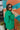 Back view of the Blakely Blazer In Green that features a green material, a collar and lapel, a two button front closure, a long sleeve, shoulder pads, two front pockets, and a back slit.