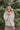 Front view of The Floral Dreams Jacket features cream coloring fabric, flower stitched pattern, two front buttoned chest pockets, cream button up with a collared neckline, two side pockets, and long sleeves with buttoned cuffs.