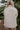 Back view of The Floral Dreams Jacket features cream coloring fabric, flower stitched pattern, two front buttoned chest pockets, cream button up with a collared neckline, two side pockets, and long sleeves with buttoned cuffs.