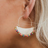 The Squared Away Earring is a dangle style earring, featuring an open gold arch, a gold half circle body, and a multi-colored beading at the edge.