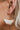 The Squared Away Earring is a dangle style earring, featuring an open gold arch, a gold half circle body, and a multi-colored beading at the edge.