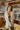 Frontal view of the happy Hour Blazer that features an ivory material, a collar and lapel, a two button front closure, a long sleeve, shoulder pads, two front pockets, and a back slit.