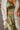 Frontal view of the First Class Pants that features a green colored material, a high rise fit, a clasp and zipper front closure, a cross button detail, belt loops, front pockets, a pleating at the waist, two back faux pockets, and a wide leg fit.