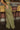 Side view of the First Class Pants that features a green colored material, a high rise fit, a clasp and zipper front closure, a cross button detail, belt loops, front pockets, a pleating at the waist, two back faux pockets, and a wide leg fit.