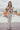 Frontal view of the Let's Chat Pants that features a beige colored material, a high-rise waist, a sweetheart cut waist hemline, a seam down the front legs, a wide leg fit, and a back zipper closure.