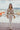 Frontal view of the Let's Chat Pants that features a beige colored material, a high-rise waist, a sweetheart cut waist hemline, a seam down the front legs, a wide leg fit, and a back zipper closure.