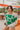 Frontal view of the just Smitten Sweater that features a taupe knit material, a green checkered design with flowers, a round neck, a long sleeve, and a flowy fit.