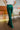 Back view of the With The Flow Pants that features a green colored velvet material, a high-rise fit, a side zipper, and a wide leg fit.