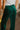 Back view of the With The Flow Pants that features a green colored velvet material, a high-rise fit, a side zipper, and a wide leg fit.
