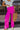 Frontal view of the Midtown Minute Pants that features a magenta colored material, a high-rise fit, a front button and zipper closure, side pockets, a pleated front, two back pockets, and a wide leg fit.