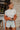 Frontal view of the See You Around Top that features a white material a high neckline, a long sleeve, lettuce edge hems, and a patchwork design.