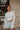 Frontal view of the See You Around Top that features a white material a high neckline, a long sleeve, lettuce edge hems, and a patchwork design.