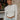 Frontal view of the See You Around Top that features a white material a high neckline, a long sleeve, lettuce edge hems, and a patchwork design.