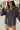 Frontal view of the Bare With Me Top that features a charcoal grey gauze material, a V neckline, a button-up front, a long cuffed sleeve, raw hemlines through out, and side pockets.
