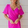 Frontal view of the Sitting Pretty Mini Dress that features a magenta colored chiffon material, a surplice neckline, short sleeves, a surplice front, a back zipper, and a mini length