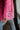 Side view of the Seasons Change Jacket that features a pink colored corduroy material, a collar and lapel neckline, a two button front closure, a long sleeve, two front pockets, and a back slit.