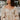 Frontal view of the love You More Top that features a champagne colored silk material, a straight neckline with a tie detail, a long sleeve, a pleated front, a smocked back, a back zipper closure, and a flowy fit.