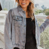 Front view of model wearing The Rhinestone Studded Denim Jacket features a light washed denim material, a collar neck, long cuffed sleeves, two front pockets at the chest with a button closure,  rhinestone stud detailing through out.