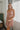 Frontal view of the Love Sick Mini Dress that features a rose gold shimmer material, a deep V neckline with a mesh lining, a sleeveless design with thick straps, a deep V back, a back zipper closure, and a mini length.