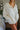 Frontal view of the Perfect Timing Top that features an ivory colored material, a collar neck, a 3/4 button-up, a long sleeve, two front pockets, and an oversized fit.