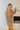 Frontal view of the Something Special Romper that features a brown colored material, a brown mix plaid pattern, a collar and lapel surplice neckline, long sleeves, front two button detail, front pocket flaps, a front flap, and a hidden zipper closure with