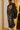Side view of model wearing The Parisian Wonder Top features a black crochet material, a high round neckline, long sheer sleeves, lace detail at the neckline, a lining underneath, and a back zipper closure.