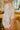 Frontal view of the Show Stopper Top that features a cream colored knit material, a high neckline, a long sheer sleeve with a floral print, and a ribbed detailing at the wrist.