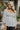 Frontal view of the Pocket Full Of Sunshine Top that features a white chiffon material, a black flower print, a sweetheart neckline, a long sleeve, a babydoll silhouette, and a smocked back.