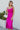 Full body front view of model wearing the Let's Dance Midi Dress, which features a fuchsia satin material, a cowl neckline, a sleeveless design with thin adjustable straps, a side slit, and a midi length.