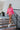 Full body front view of model wearing the Out Of Your League Top, which has a hot pink material, a collar neck, a long sleeve, a 3/4 button-up front, a patch-work design, and a wide cropped fit.
