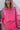 Front view of model wearing the Out Of Your League Top, which has a hot pink material, a collar neck, a long sleeve, a 3/4 button-up front, a patch-work design, and a wide cropped fit.