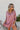 Front view of model wearing the Always On My Mind Top, which features a mauve satin material, a collared neckline, a gold button-up front, long cuffed sleeves, a high-low design, and a flowy fit. 