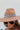 The Pretty In Paisley Hat is a wide brim hat featuring a camel colored fabric featuring a brown belt with a black and white paisley design finished with adjustable ties within for adjusted fit.