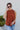 Front view of model wearing the Falling For You Top, which features a rust colored material, a rounded neck with a ruffle detail, a smocked top, a sleeveless design with thick straps, a flowy fit, and a back button closure a the neck