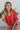 Frontal view of the Best Of My Love Top that features a deep V neckline, a half sleeve with a ruffle detail, a ruched front with adjustable ties, a high-low design, and a flowy fit.