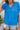 Frontal view of the Irreplaceable Top that features a royal blue material, a round neckline with a ruffle detail, a cut-out at the chest with adjustable ties, a short smocked sleeve, and a flowy fit.