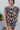 Frontal view of the Untamed Florals Top that features a black colored material, a floral print, a round neckline, a short ruffle sleeve, smock detailing at the shoulders, a back button closure, and a flowy fit.