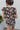 Back view of the Untamed Florals Top that features a black colored material, a floral print, a round neckline, a short ruffle sleeve, smock detailing at the shoulders, a back button closure, and a flowy fit.