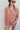 Frontal view of the Jump Start Top that features a marsala colored material, a collar neckline, a button-up front, a cuffed long sleeve, a front pocket a high-low design, and a flowy fit