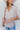 Frontal view of the Back In Session Top In Taupe that features a taupe colored material, a collar neckline, a button-up front, an oversized half sleeve, a high-low design, and a flowy fit.