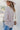Back view of the Back In Session Top In Taupe that features a taupe colored material, a collar neckline, a button-up front, an oversized half sleeve, a high-low design, and a flowy fit.