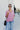 Frontal view of the Back In Session Top In Rose that features a rose colored material, a collar neckline, a button-up front, an oversized half sleeve, a high-low design, and a flowy fit.