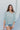 Frontal view of the Back In Session Top In Spruce that features a sage colored material, a collar neckline, a button-up front, an oversized half sleeve, a high-low design, and a flowy fit.