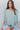Frontal view of the Back In Session Top In Spruce that features a sage colored material, a collar neckline, a button-up front, an oversized half sleeve, a high-low design, and a flowy fit.