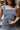 Frontal view of the Half Of My Heart Tank Top that features a black and white gingham print, a straight neckline, a sleeveless design with thick straps, and a side zipper closure.