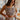 Frontal view of the Check Mate Crop Top that features a brown and white checkered print, a straight neckline, a sleeveless design with thin straps, a cropped fit, and a back zipper closure.