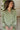 Frontal view of the On To The Next Top that features an olive green satin material, a collar neckline, a long sleeve with feather detailing at the cuff, a button-up front, and a flowy fit.