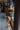 Frontal view of the One To Watch Skort that features a black faux-leather material, a thick elastic waist band with a tie detail, a tiered ruffle design, a shorts lining, and a flowy fit.